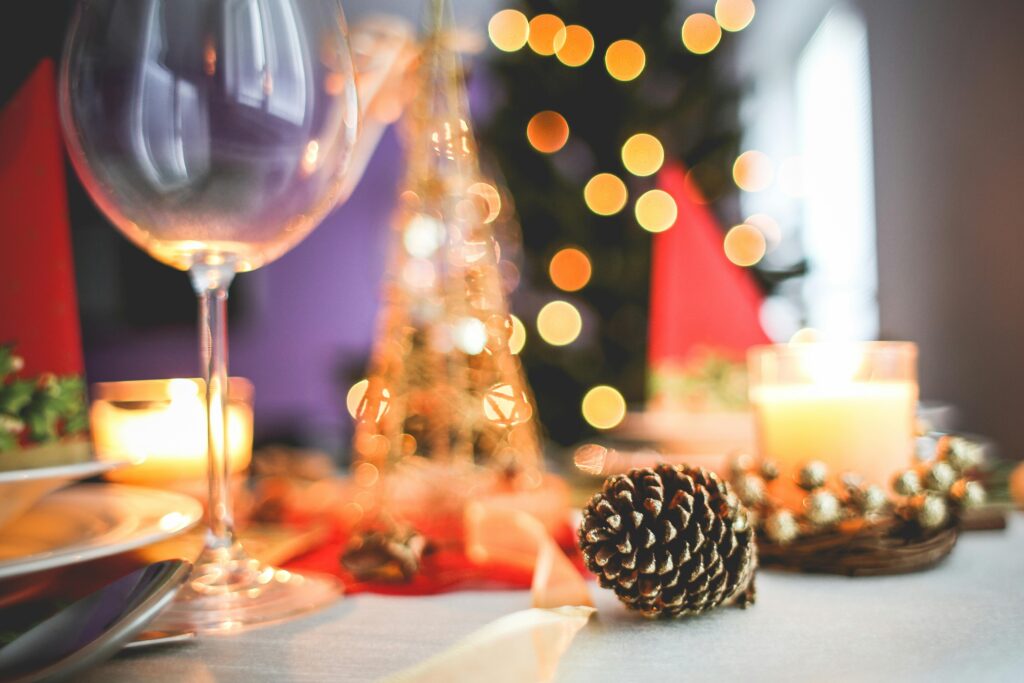Stemningsfuldt julebord med levende lys, julekugler og fyrrekogler i varme farver – DJ Gram tilbyder professionel DJ-service til julefrokoster, vinterfester og private juleevents i hele Danmark.