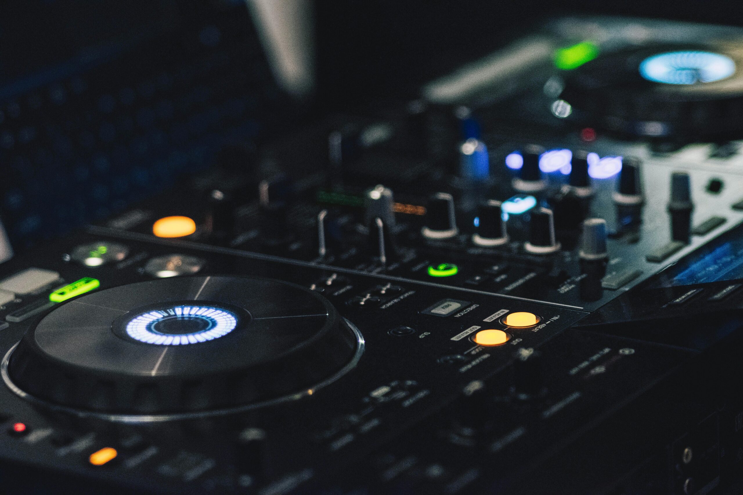 Nærbillede af professionelt DJ-mixerpult med knapper, lys og drejeskiver – DJ Gram tilbyder mobil DJ-service med avanceret lydudstyr til private events, firmafester og bryllupper i hele Danmark.